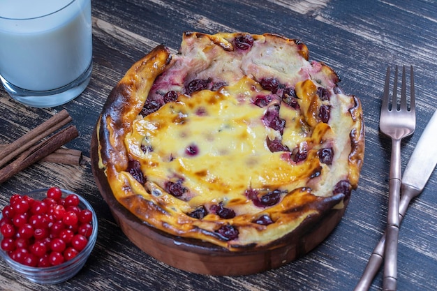 Sweet cottage cheese casserole with gooseberry and semolina on wooden table Ceramic bowl with baked cottage cheese casserole