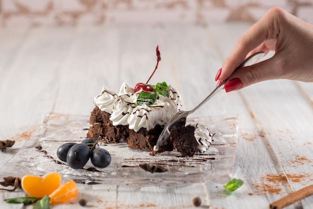 Sweet creamy cake with fruits on the white wooden background