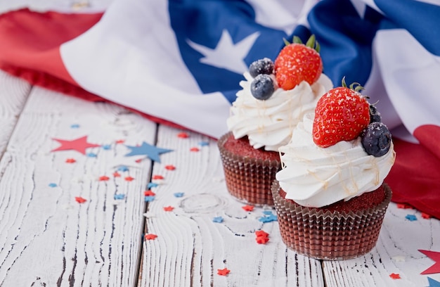 Sweet cupcakes with blueberries and strawberry flag background