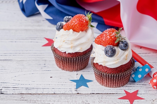 Sweet cupcakes with blueberries and strawberry usa flag on blue background