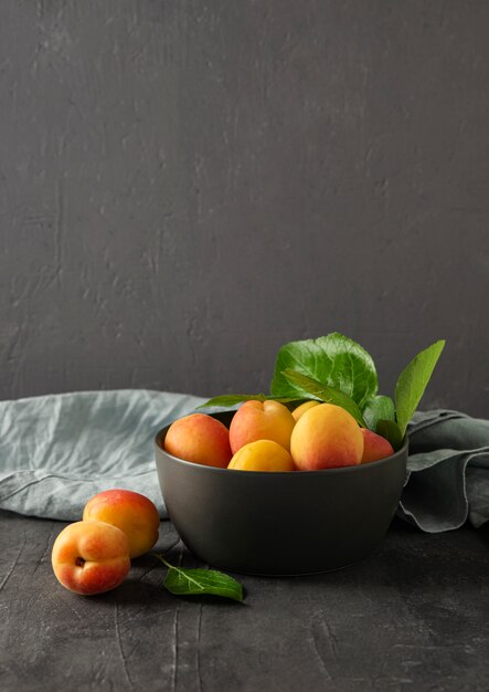 Sweet delicious apricot on dark bowl grey table summer fresh fruit