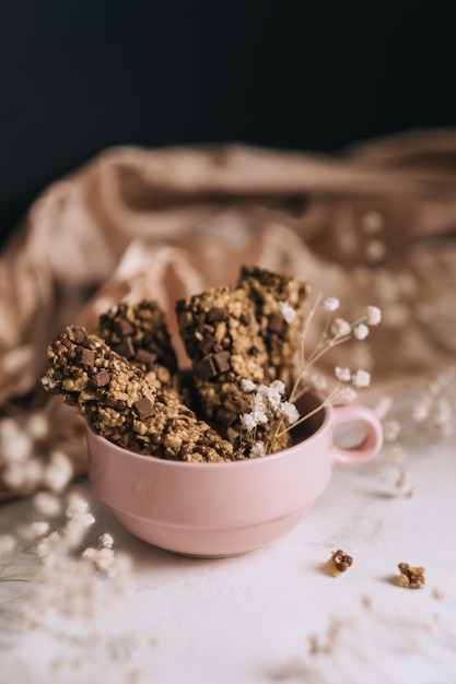 Sweet dessert, chocolate bar in a pink cup, decorated with white gypsophila flowers