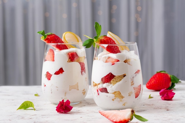 Sweet dessert in glass with biscuit berry fruit and whipped cream