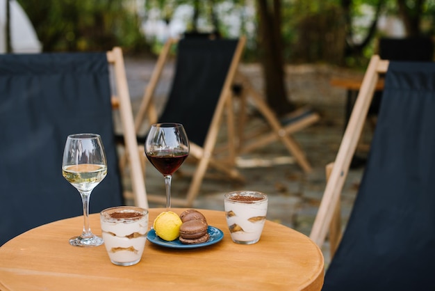 Sweet dessert of tiramisu and glasses of wine outdoors on the restaurant terrace