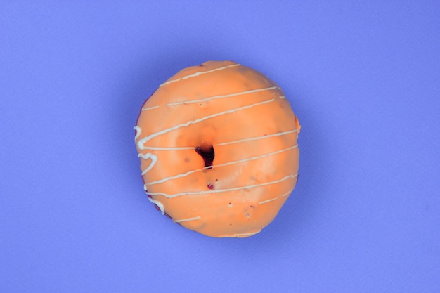 Sweet donut glazed on a purple background Closeup of a sweet dessert View from above