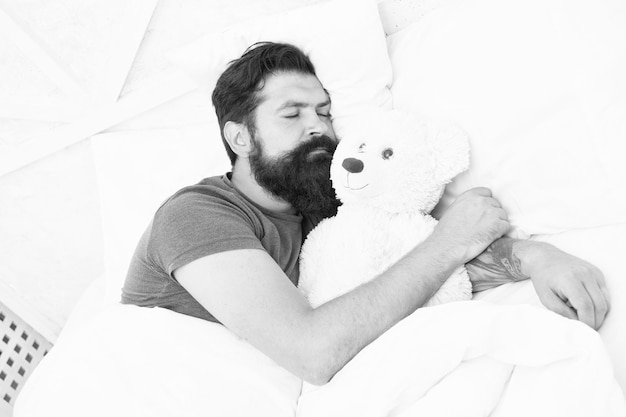 Sweet dreams Bearded hipster play toy Valentines day gift Man sleep hug soft toy relaxing in bed Cute teddy bear toy Softness tenderness Playful adult fall asleep Good night Sleep well