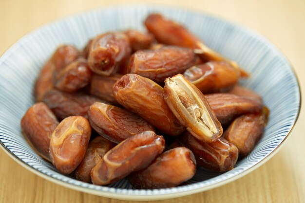 Sweet dried dates fruit in a bowl and on the table