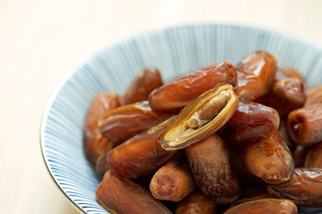 Sweet dried dates fruit in a bowl and on the table