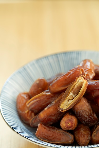 Sweet dried dates fruit in a bowl and on the table