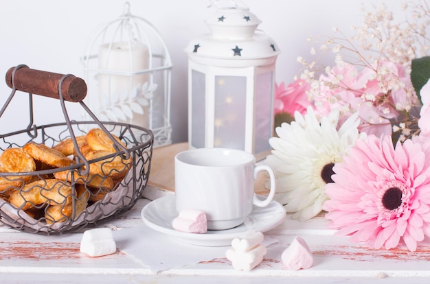 Sweet ears cookies in a metal basket Flowers and sweets on a white background