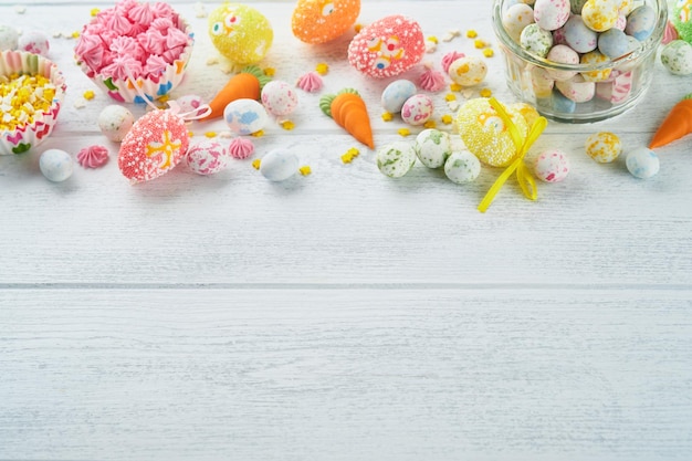 Sweet Easter concept Sweet Easter kids holiday assortment marshmallows rabbit chocolates easter eggs candies bunny snacks on white wooden background Flat lay Easter decoration idea Mock up