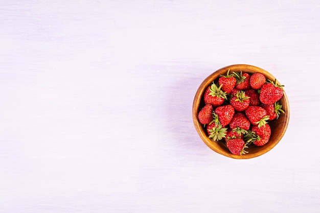 Sweet fresh ripe strawberry isolated on pink background.