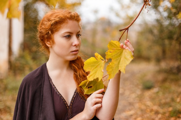 Sweet girl in the autumn forest, loneliness and melancholy