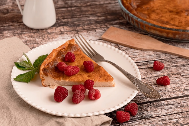 Sweet home-made cheesecake served with raspberries on a white plate