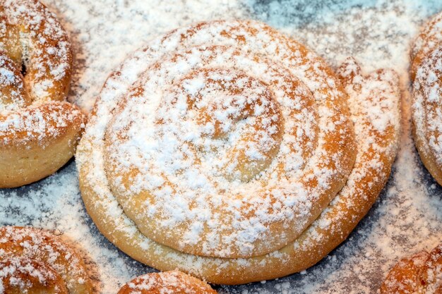 Sweet homemade cakes sprinkled with vanilla sugar Small cookies from the oven on a baking sheet