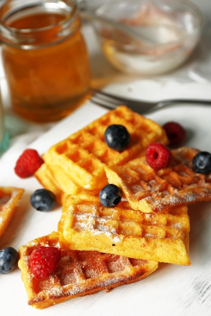 Sweet homemade waffles on tray on light background