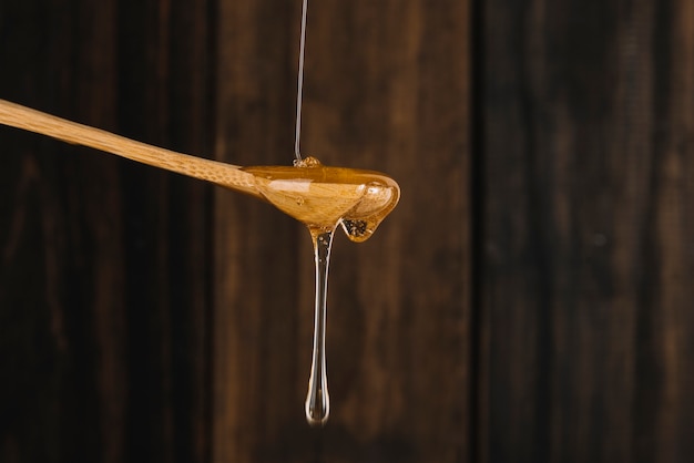 Sweet honey dripping from wooden spoon