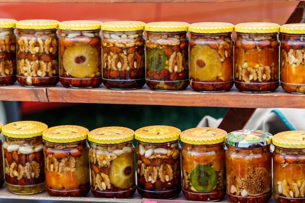 Sweet honey with nuts and fruits in glass jars