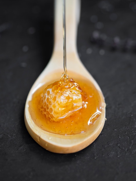 Sweet honeycomb on wooden spoon