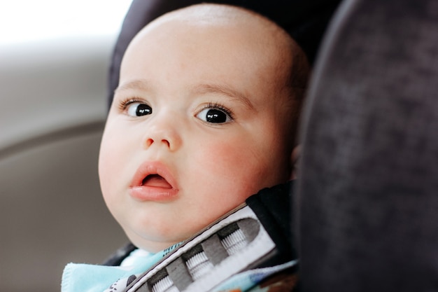 Sweet infant in the car sits in a child seat. Safe driving. Baby care