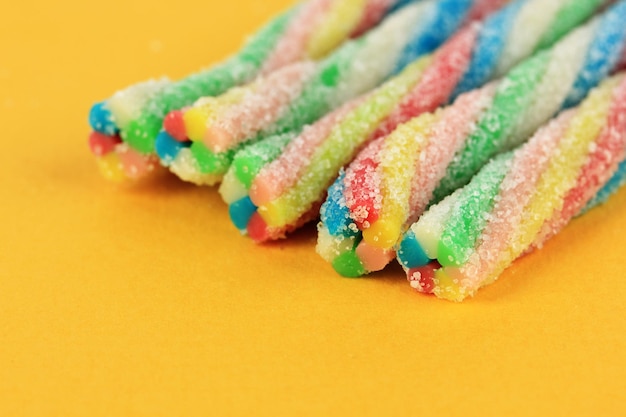 Sweet jelly candies on yellow background