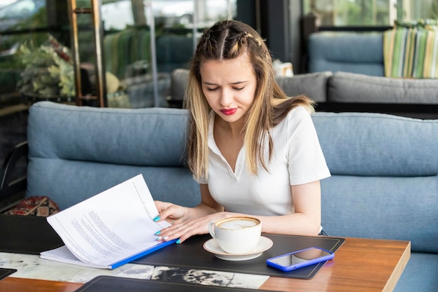 Sweet lady sitting at the restaurant and looking at her notes