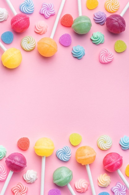 Sweet lollipops and candies on pink background