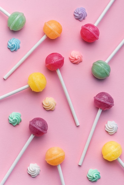 Sweet lollipops and candies on pink background