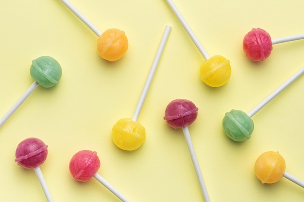 Sweet lollipops on yellow background