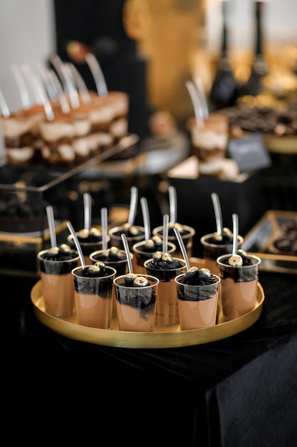 Sweet luxury candy bar on table in restaurant in black tone Cakes and other sweets