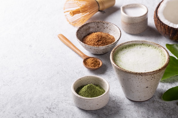 Sweet matcha latte Japanese green tea with coconut milk on white background copyspace.