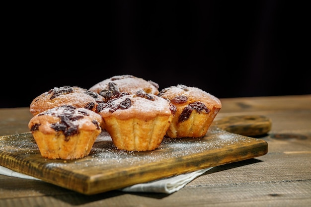 Sweet muffins with raisins on the board Copy space The concept of food pastries desserts