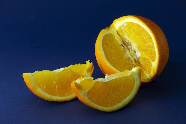 A sweet orange with two slices next to it is a subject photography Orange fruit still life photo