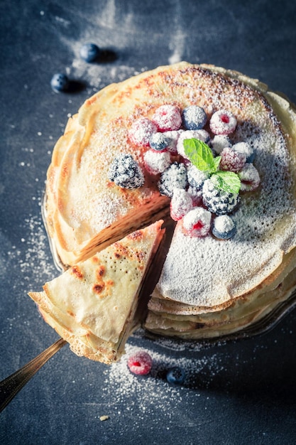 Sweet pancakes cake with fresh berries and mint