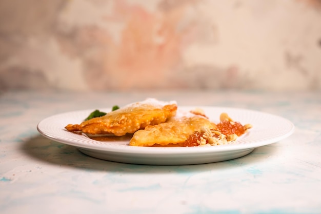 sweet pasties with sugar sprinkles on a white plate