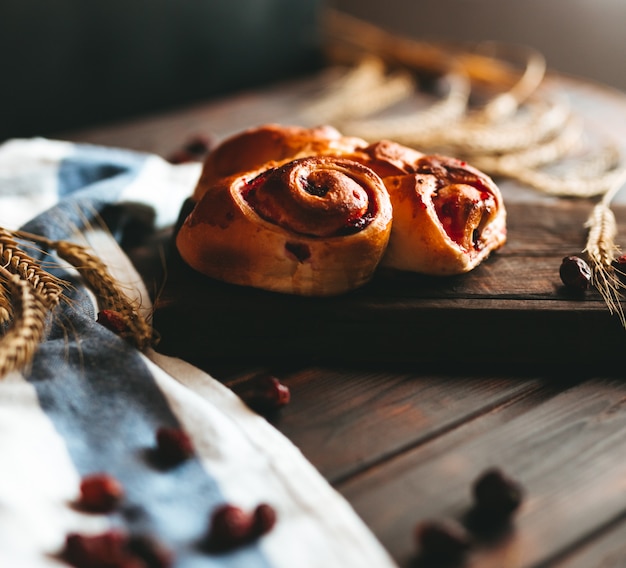 A sweet pastry made of strawberry jam and dogberry over rustic wooden table