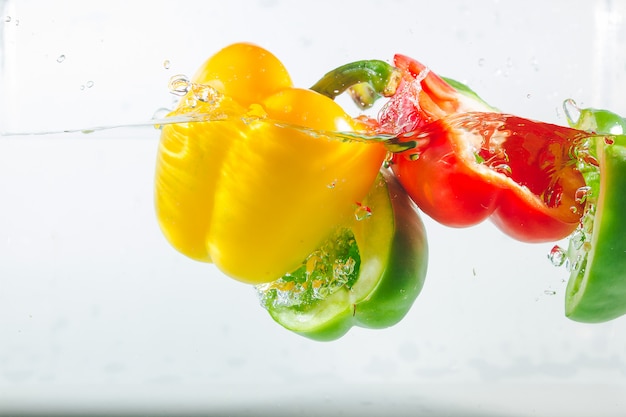 Sweet pepper in the yellow, red, green splashes of water, Sweet pepper on white