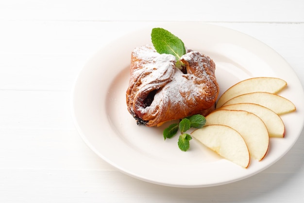 Sweet pie on a plate on wooden table