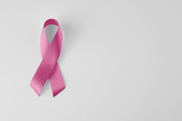 Sweet pink ribbon shape on pink background paper for breast cancer awareness symbol to promote in the month of October campaign