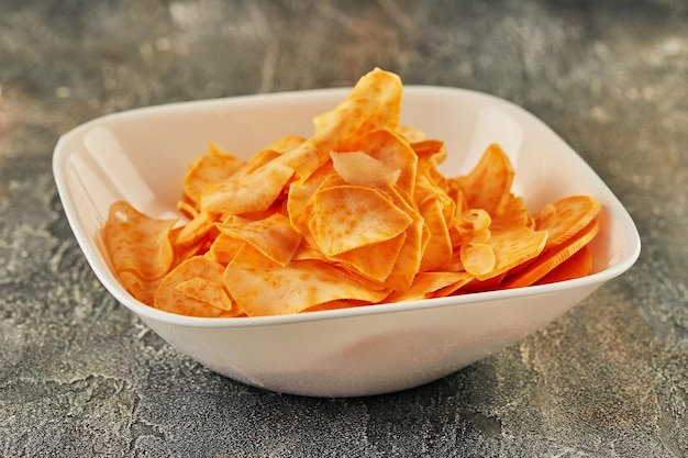 Sweet potato chips in white plate are ready to be eaten