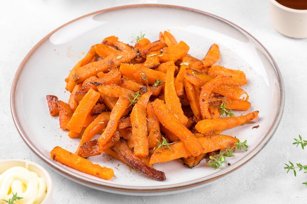 Sweet potato fries on a plate with mayo and ketchup bbq sauce homemade roasted in the oven