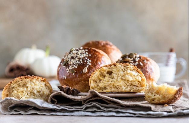 Sweet pumpkin buns with cinnamon and anise, light concrete background. Selective focus.