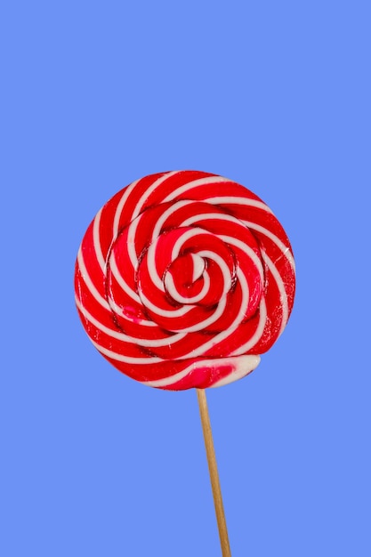 Sweet red lollipop on blue background