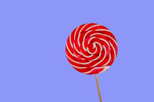 Sweet red lollipop on blue background