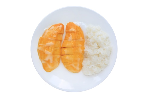 Sweet ripe golden mango and sticky rice pour topped with coconut cream on white circle ceramic plate isolated on white background.