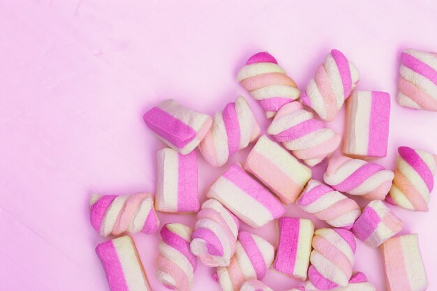 Sweet small marshmallows on a pink background