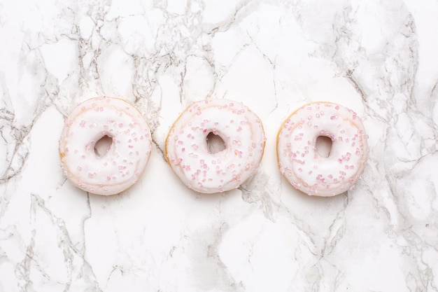 Sweet strawberry donuts on marble surface isolated flat lay, minimalism, food