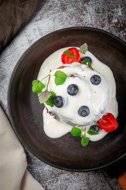 Sweet summer dessert ice cream made of cream sugar berry puree and seasonal berries with cheese cream and powdered sugar