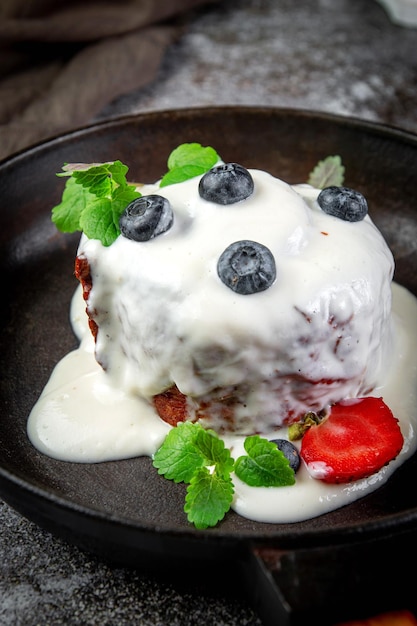 Sweet summer dessert ice cream made of cream sugar berry puree and seasonal berries with cheese cream and powdered sugar