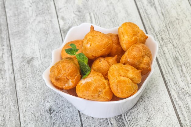 Sweet tasty profiteroles heap in the bowl